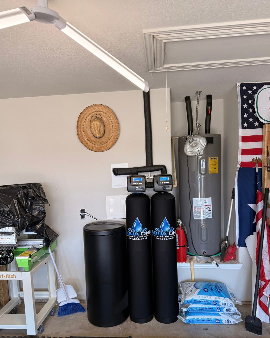 An Aqua One softener and carbon filtration system installed in a Permian Basin garage